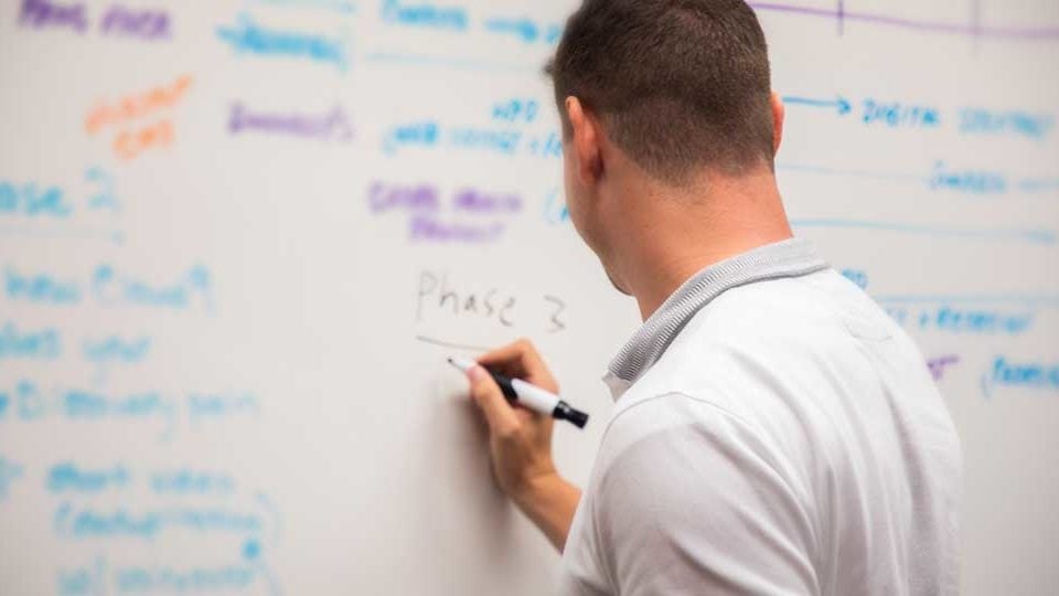 A man writing on a blackboard