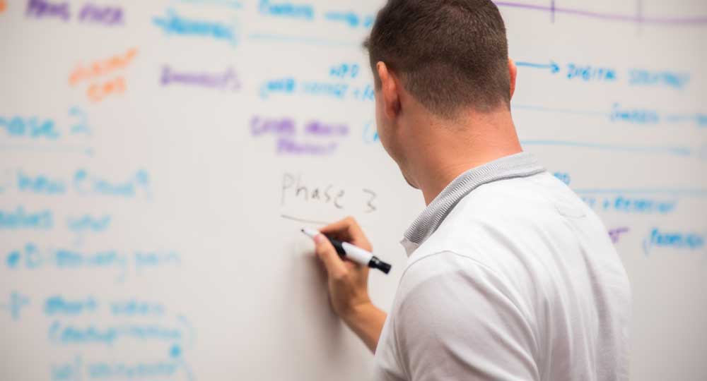 A man writing on a blackboard