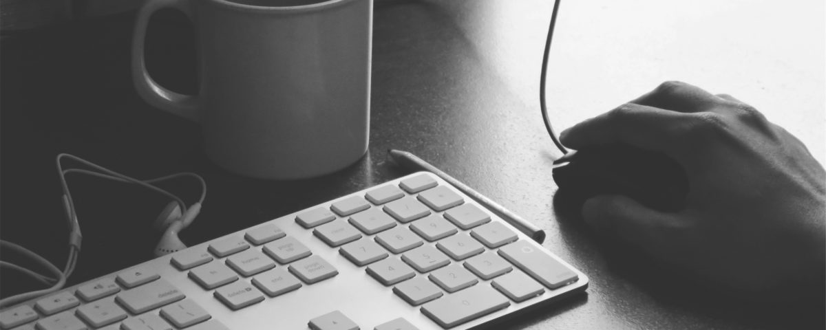 A man holding a computer mouse on a desk