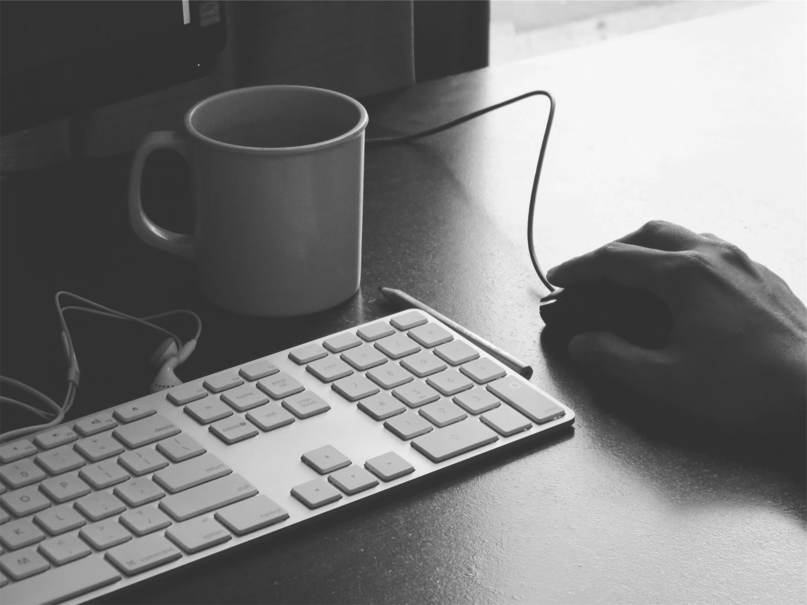 A man holding a computer mouse on a desk