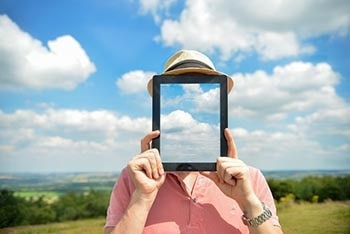 A man in the nature holding a tablet