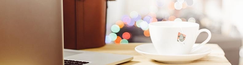 A laptop and a coffee cup on a desk