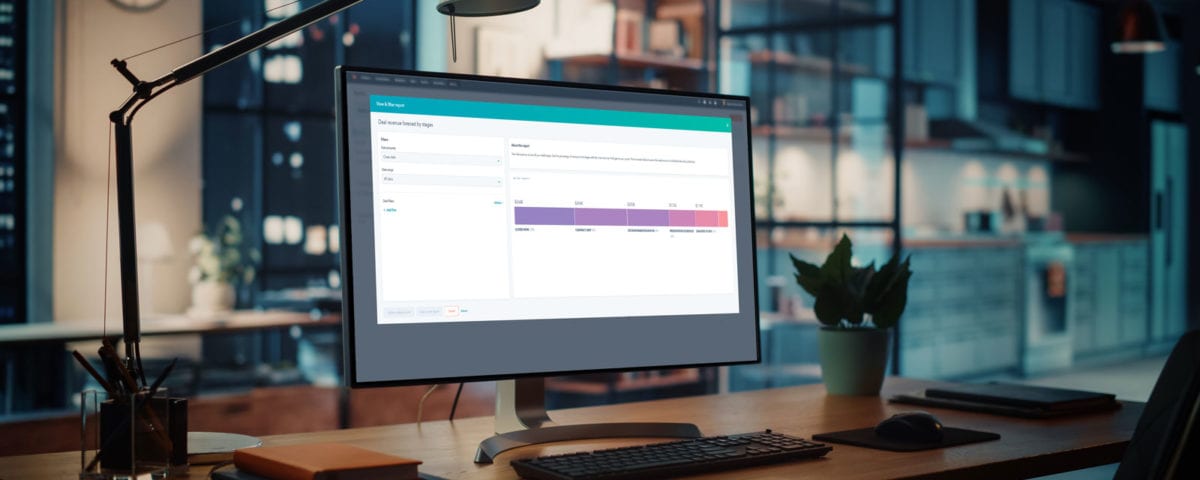 a computer on a desk displaying a Hubspot dashboard