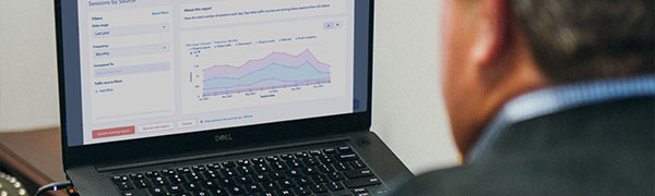 A man looking at a computer screen back angle