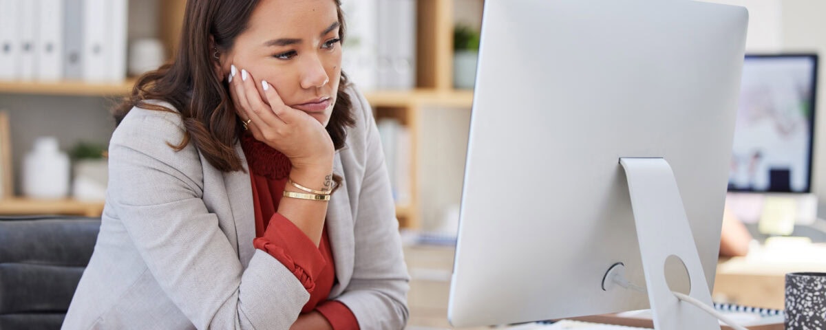 A frustrated women staring at her laptop in her office