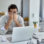 A businessman frustrated in front of his laptop
