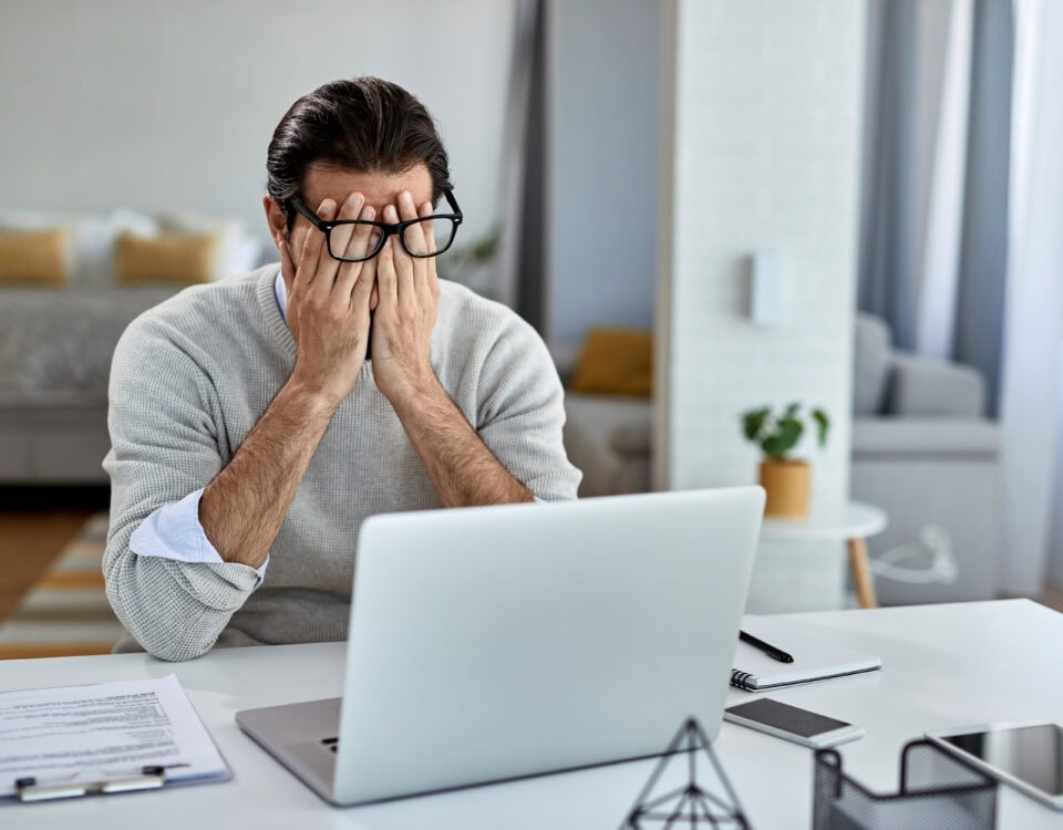 A businessman frustrated in front of his laptop