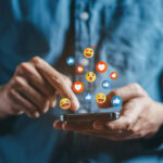 A person scrolling on social media with reactions floating above the phone